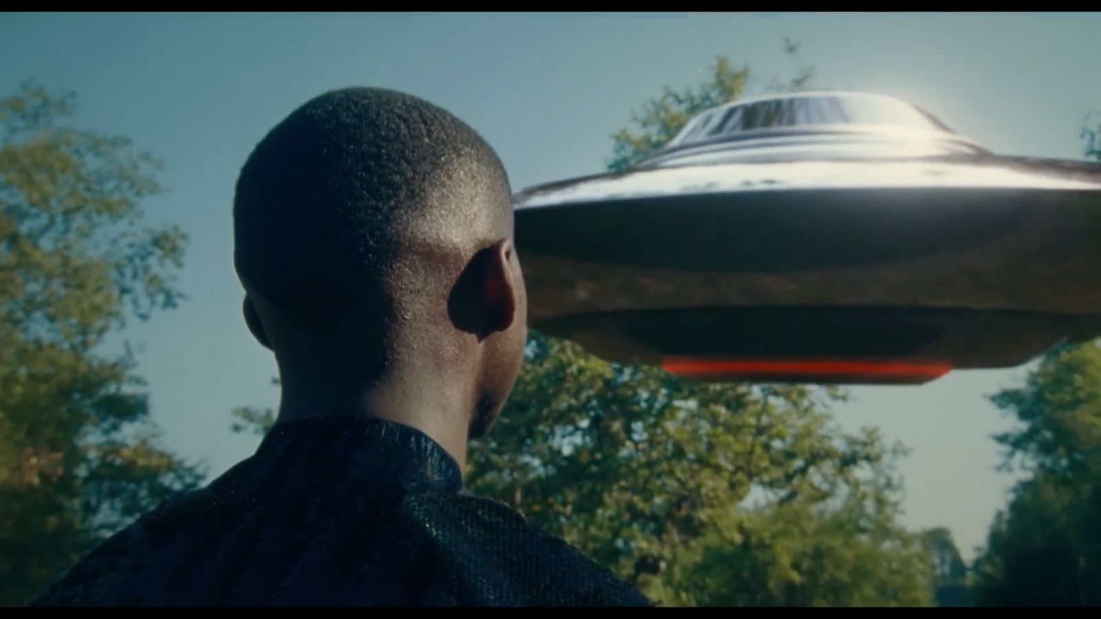 a man looking at a flying object in the sky