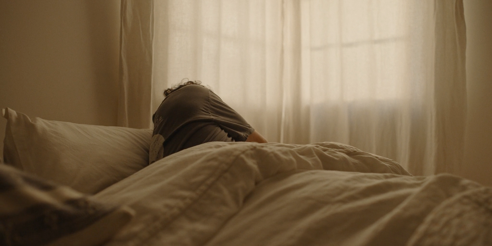 a person laying in bed with their head on a pillow