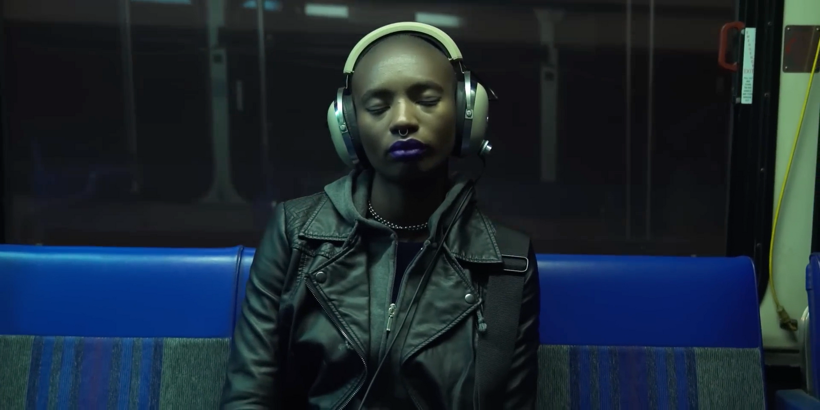 a woman wearing headphones sitting on a train