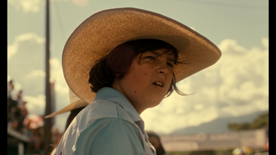 a woman wearing a large hat and a blue shirt