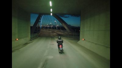 a motorcyclist rides through a tunnel at night