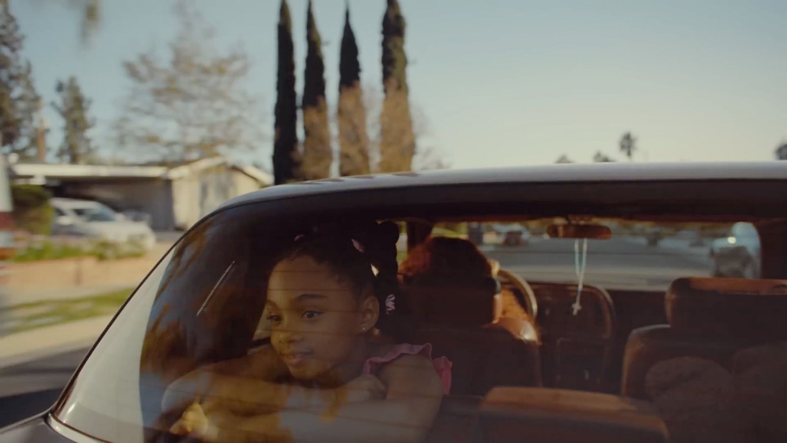 a little girl sitting in the passenger seat of a car