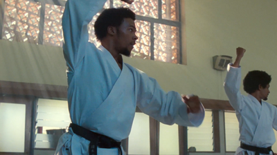 two men doing karate moves in a gym