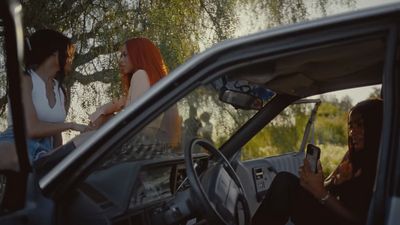 two women sitting in a car talking to each other