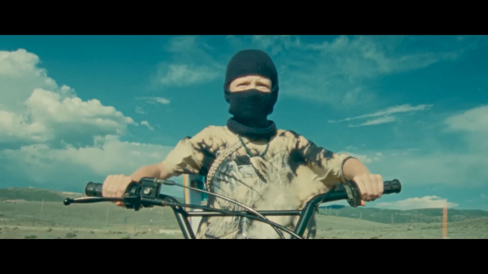 a man wearing a mask riding a bike