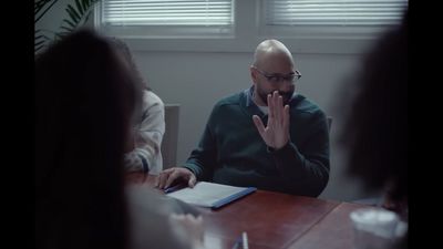 a man sitting at a table in front of a laptop