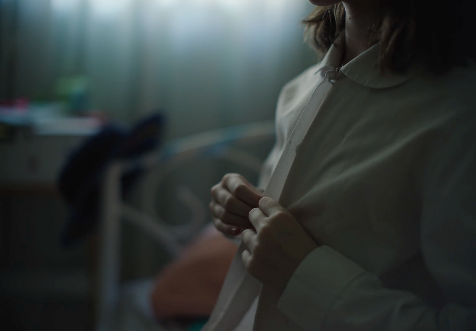 a woman standing in a room with a white shirt on