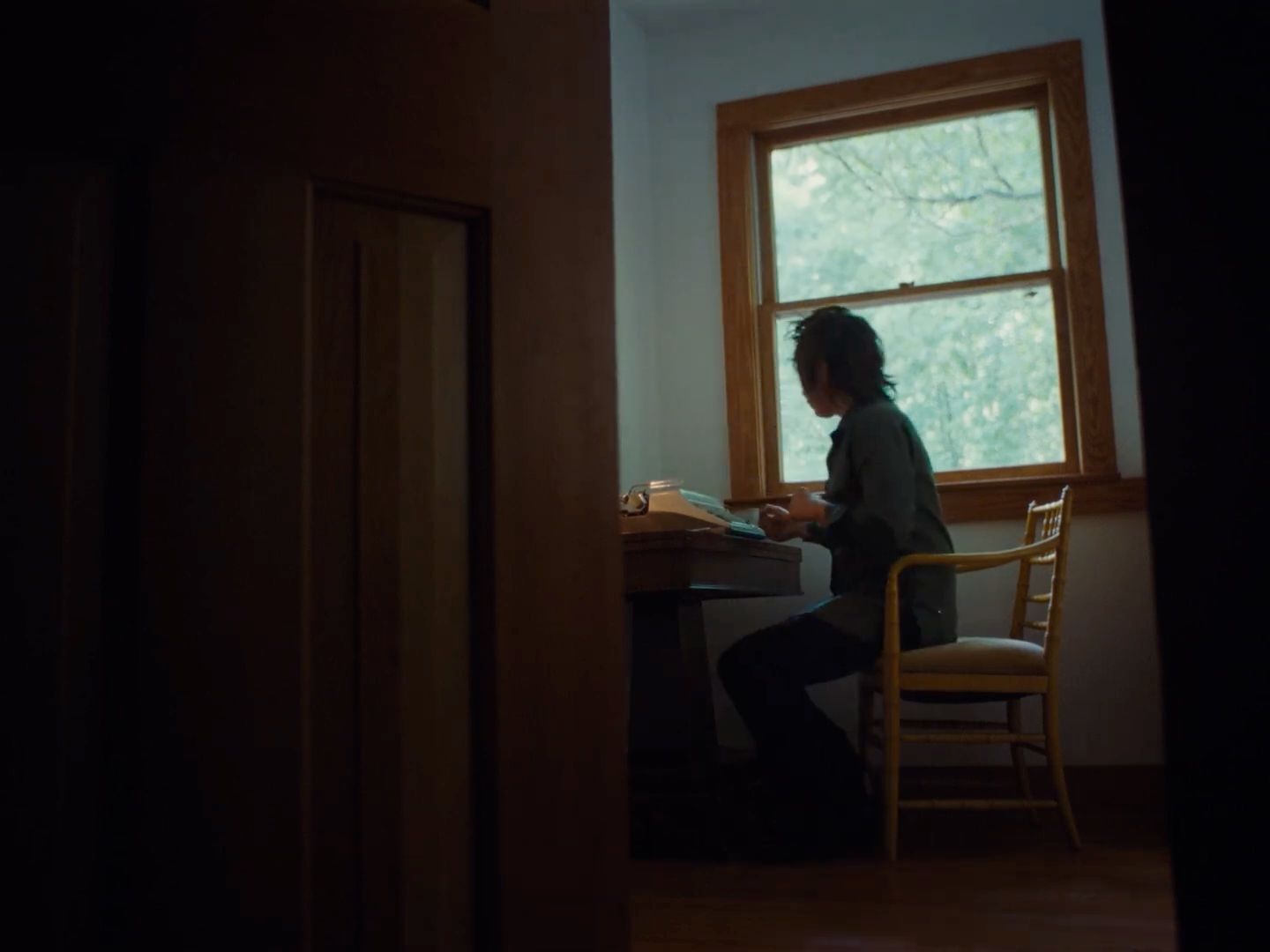 a person sitting at a table in front of a window