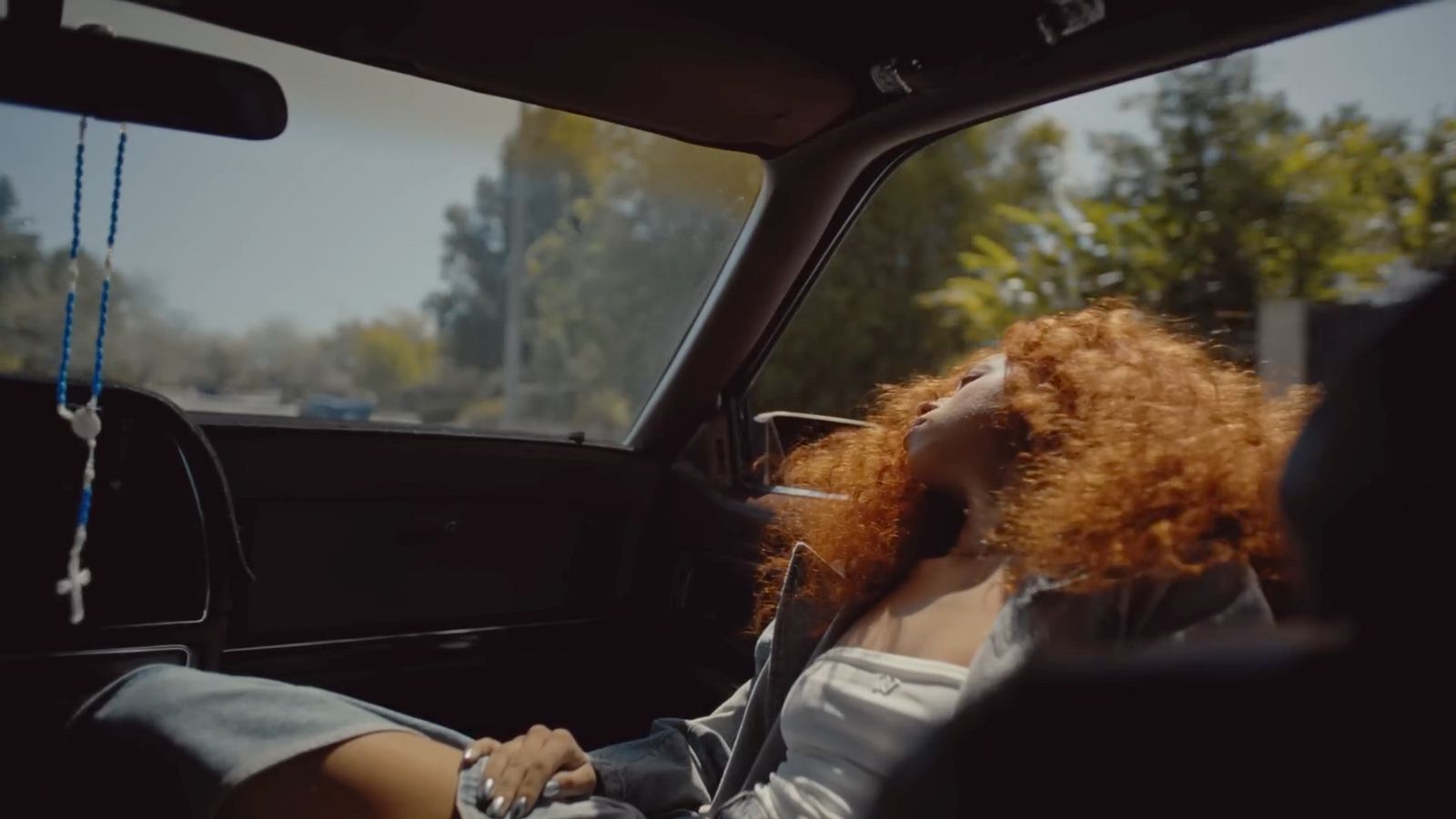 a woman with red hair sitting in a car