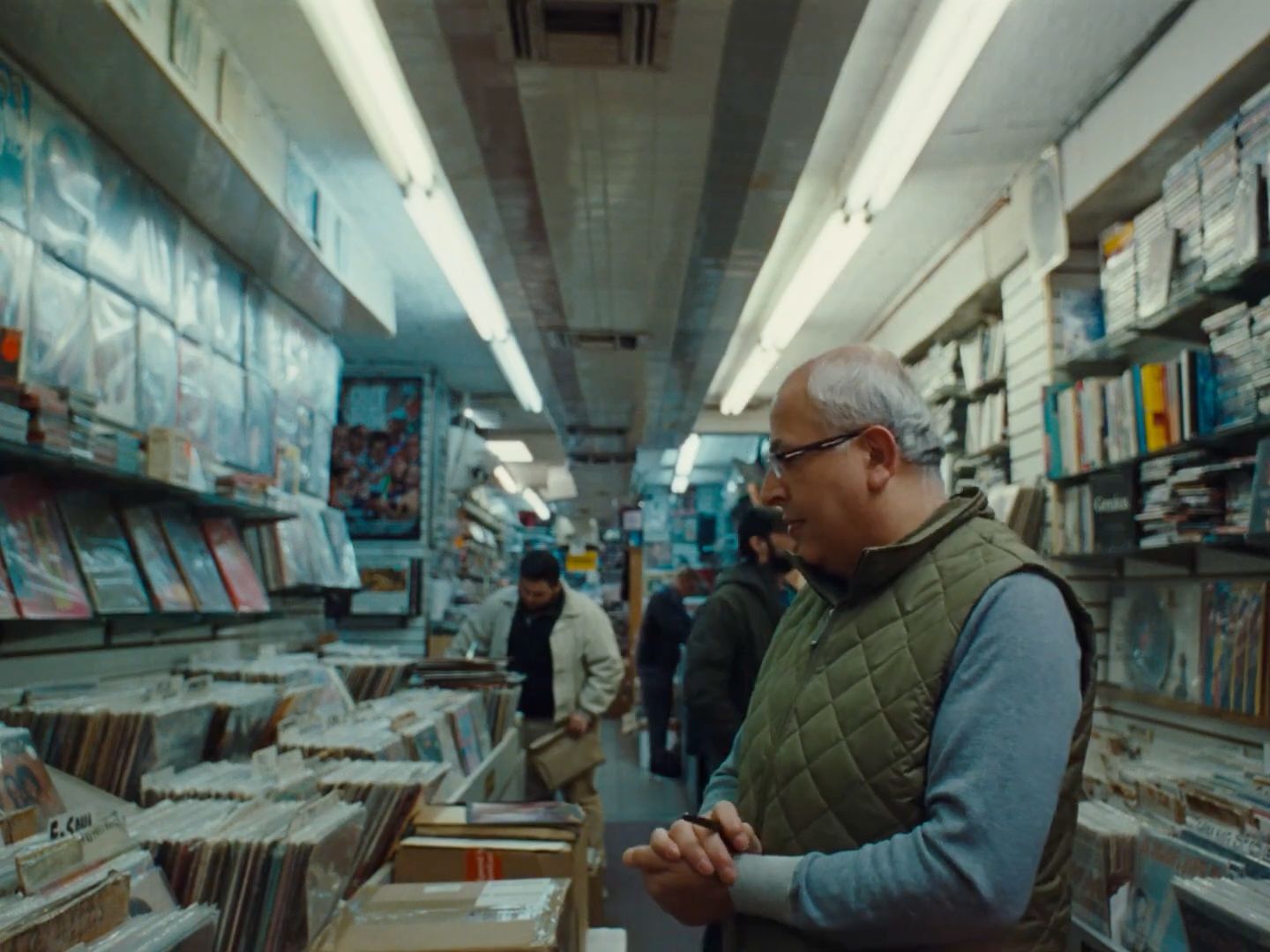 a man standing in a store looking at cds