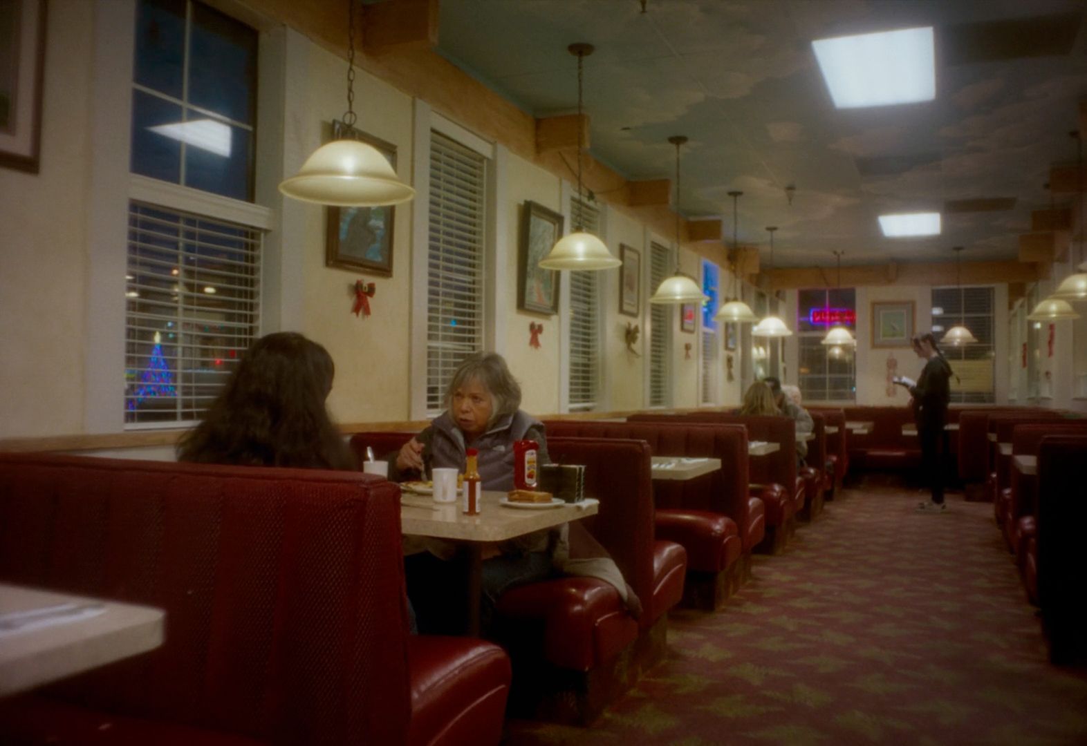 a woman sitting at a table in a restaurant