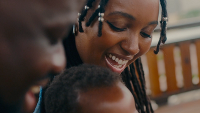 a woman smiles as she holds a child