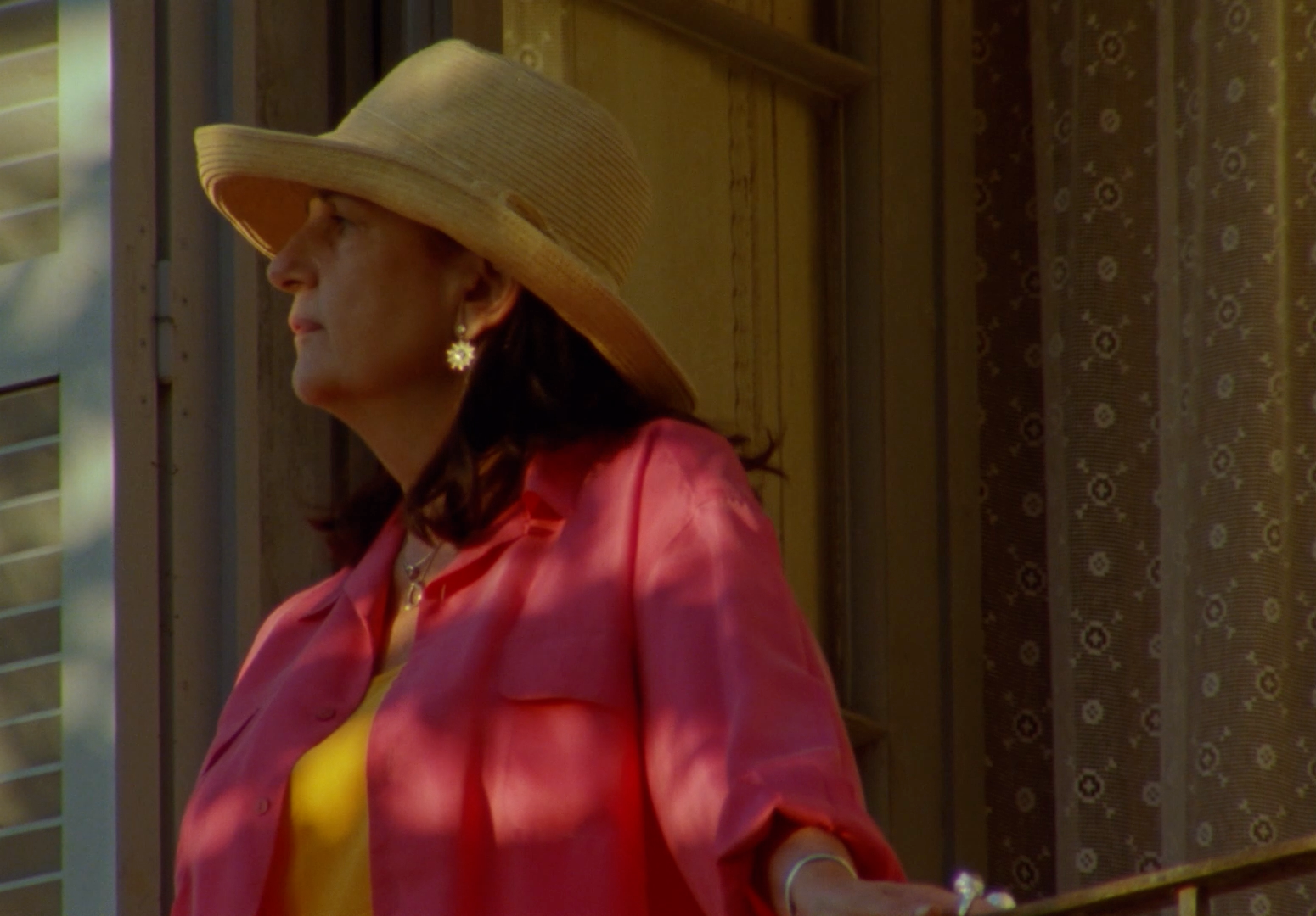 a woman in a pink shirt and a tan hat