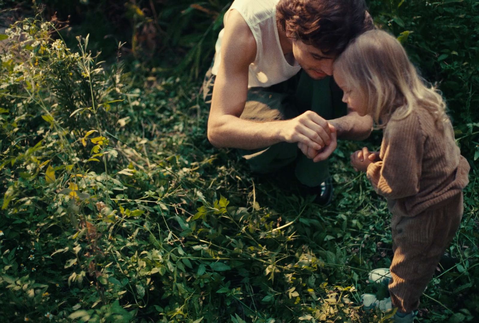 a man kneeling down next to a little girl