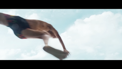 a man in a swimming suit jumping into the air