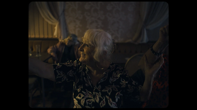 an older woman holding a remote control in her hand