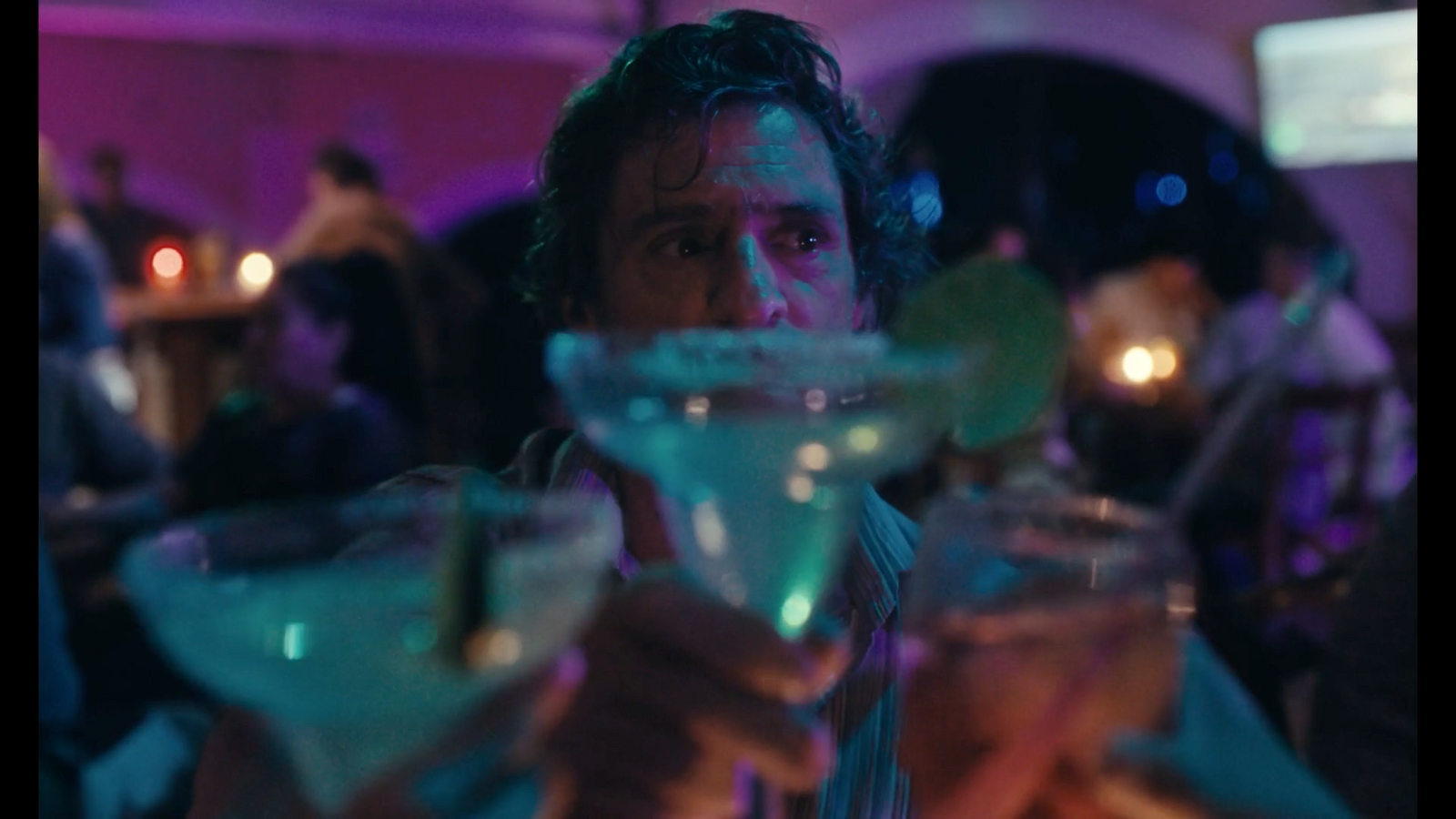 a man holding a martini glass in front of his face