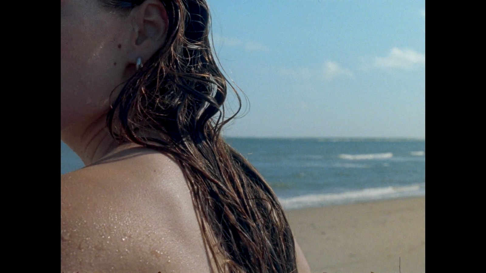 a woman standing on a beach next to the ocean