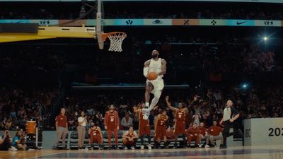 a man dunking a basketball in front of a crowd