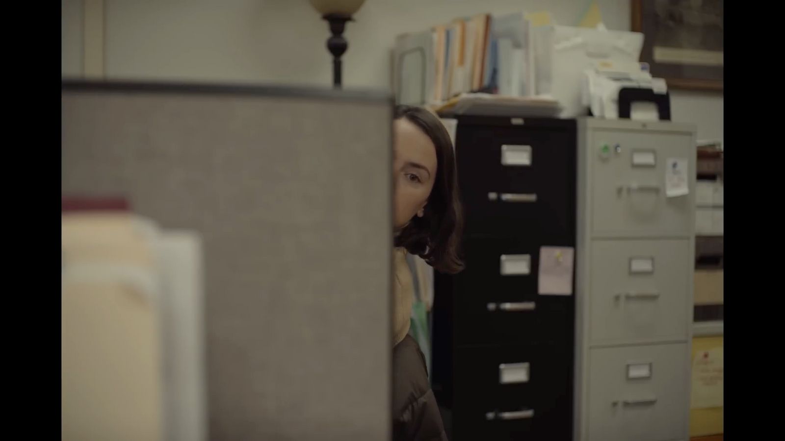 a woman standing in front of a filing cabinet