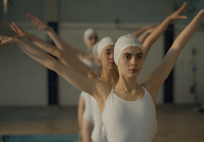 a group of women in white leotards and turbans