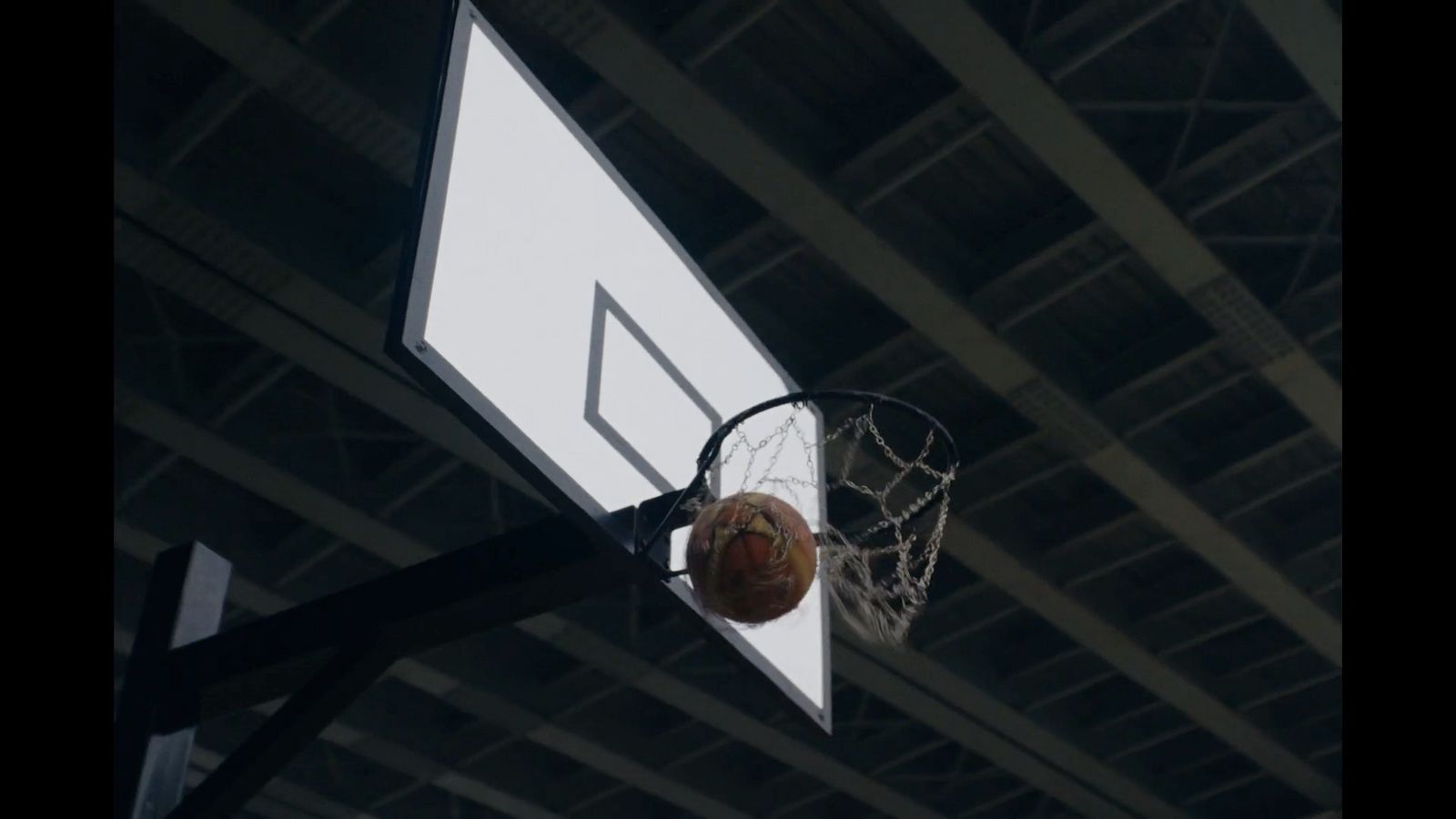 a basketball going through the hoop of a basketball court