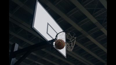 a basketball going through the hoop of a basketball court