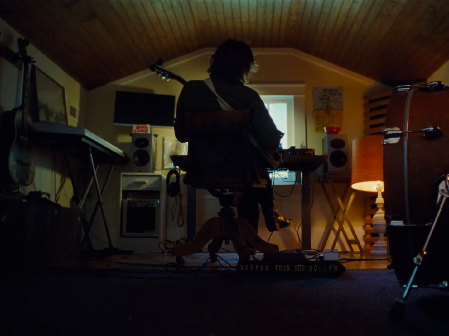 a person standing in a room with a guitar