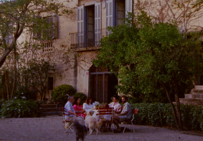 a group of people sitting around a table with dogs