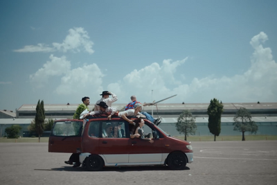 a group of people sitting on top of a car