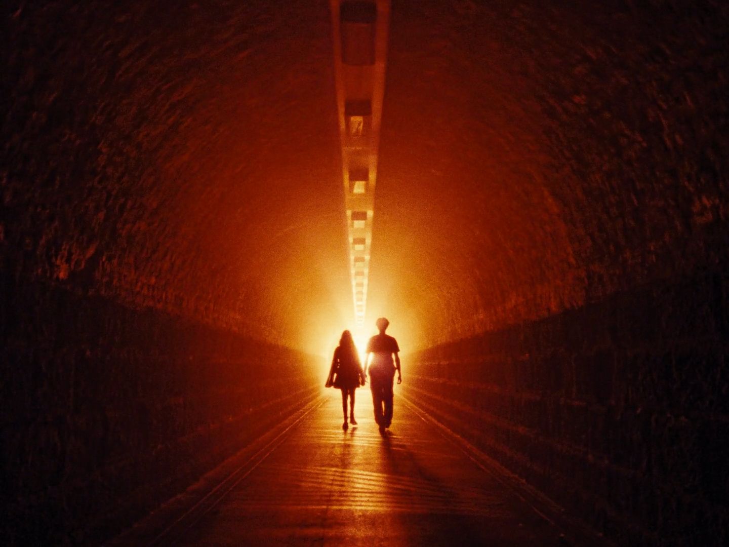 a couple of people that are walking in a tunnel