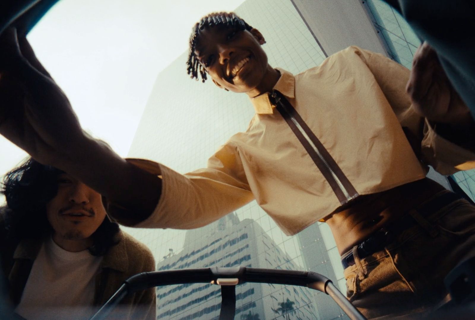 a man standing in front of a tall building talking on a cell phone