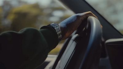 a hand on the steering wheel of a car