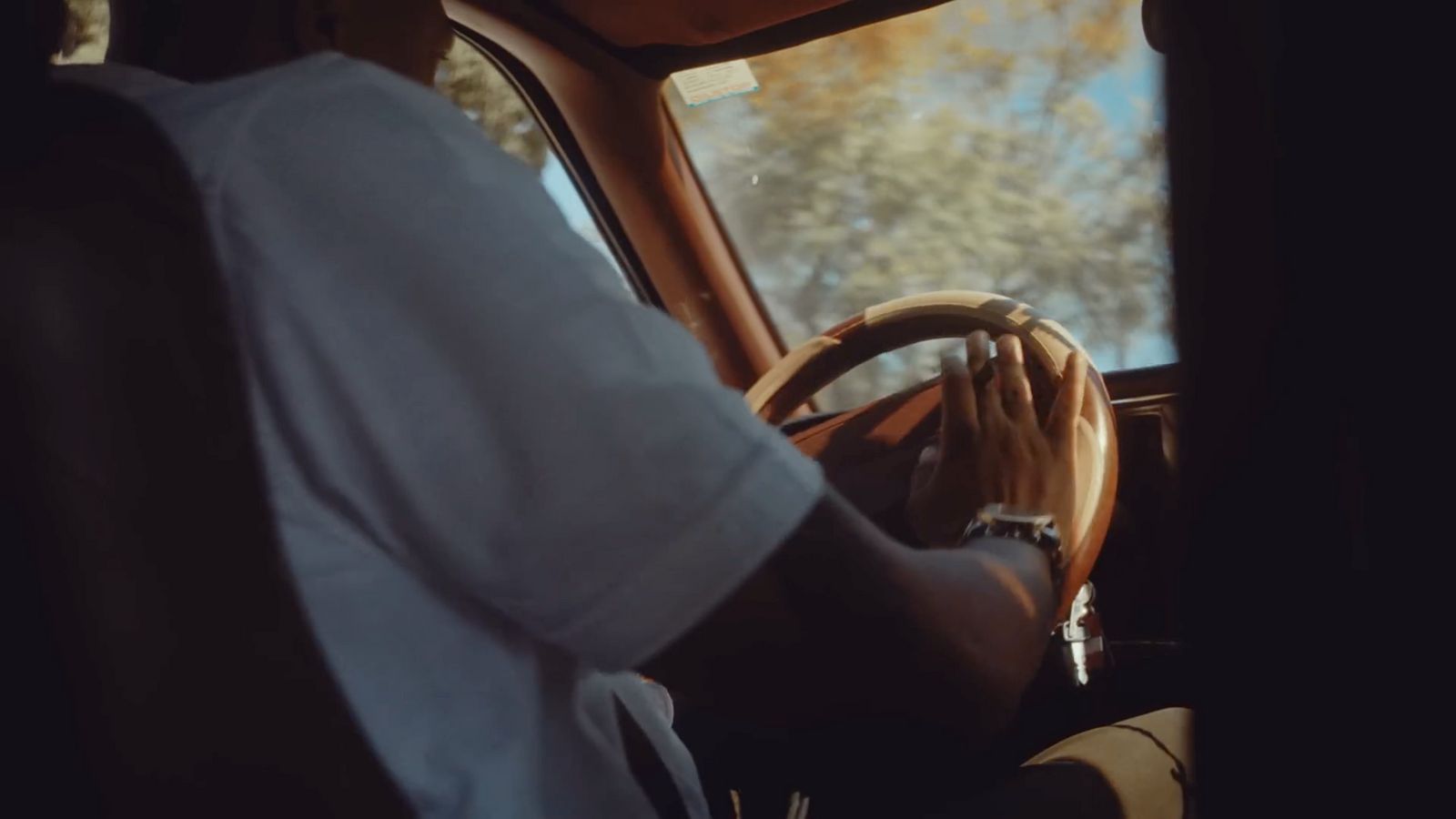 a man driving a car with a steering wheel