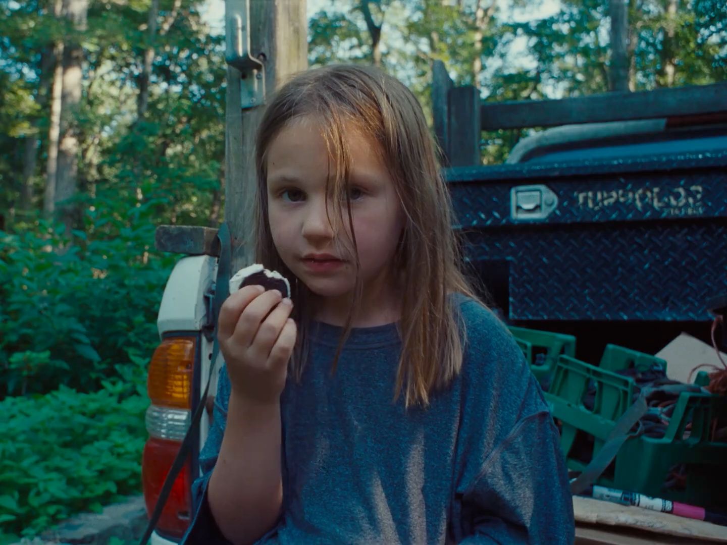 a young girl holding a piece of food in her hands