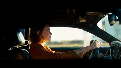 a woman driving a car on a highway