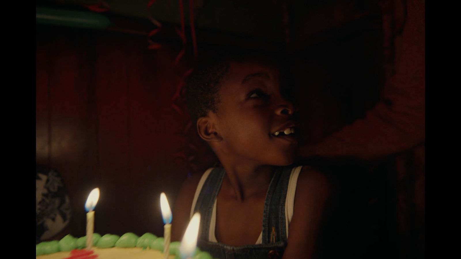 a young child is blowing out candles on a birthday cake