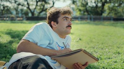 a man laying in the grass reading a book