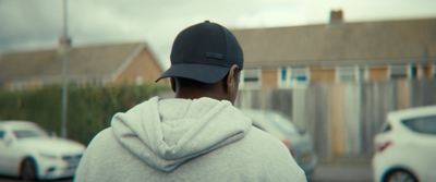 a person in a hoodie is standing in front of a house