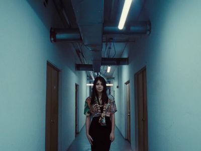 a woman is walking down a long hallway