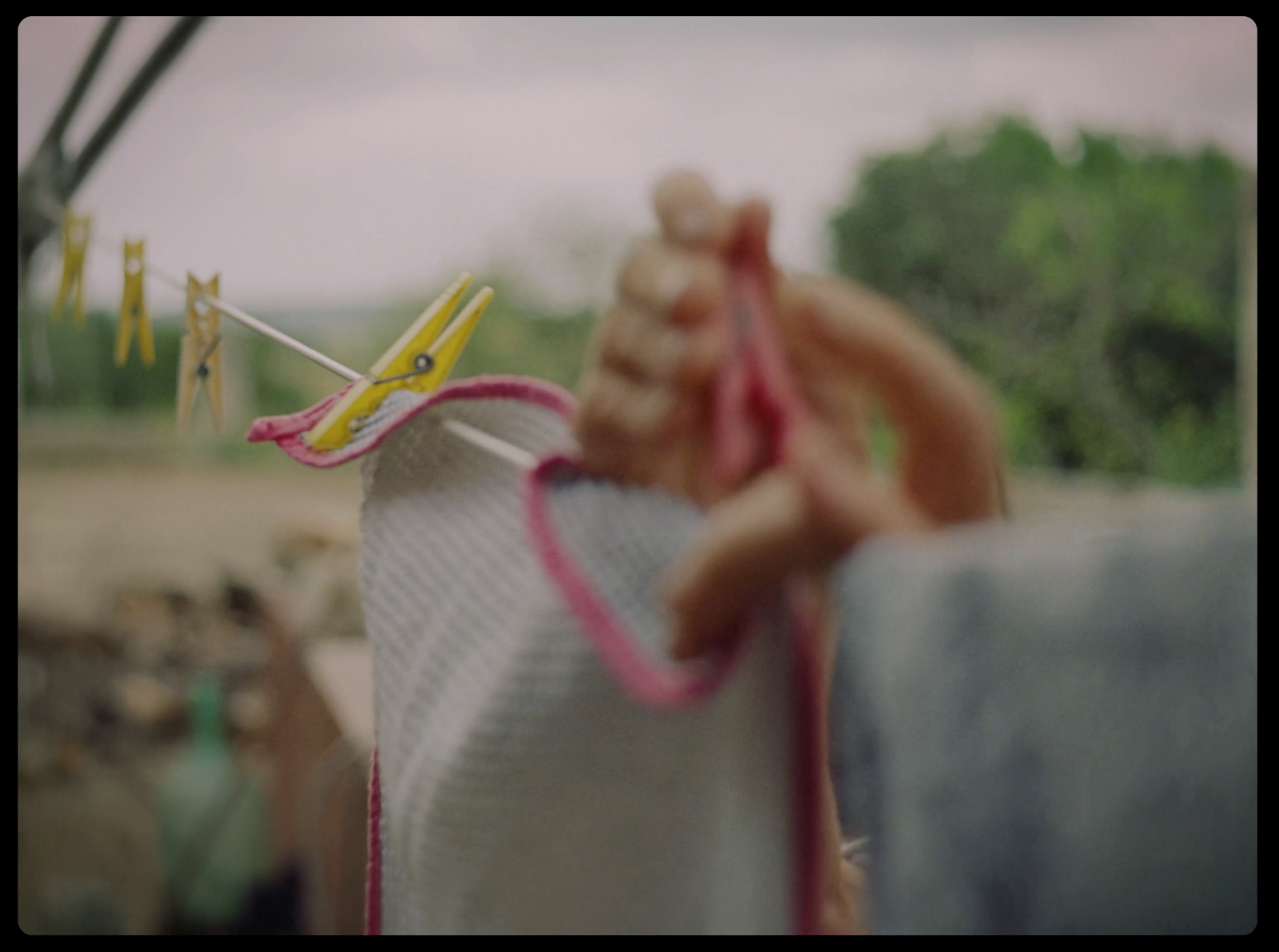 a hand holding a string of clothes on a clothes line