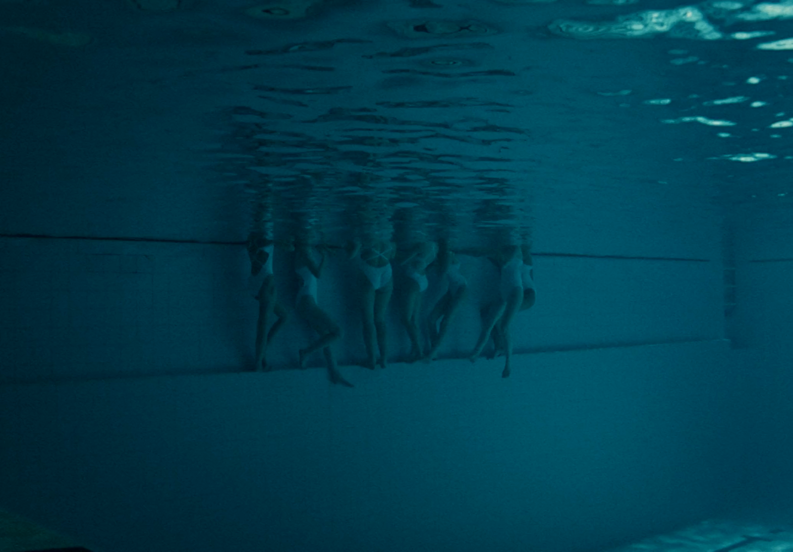 a group of people swimming under water in a pool