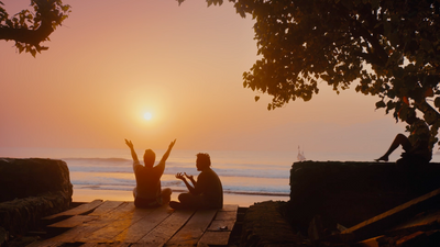 a couple of people sitting on top of a wooden platform