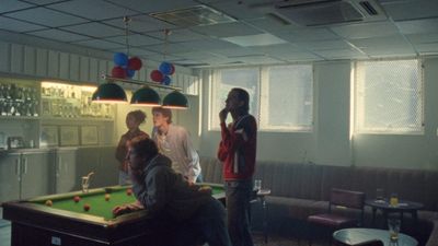 a group of people standing around a pool table