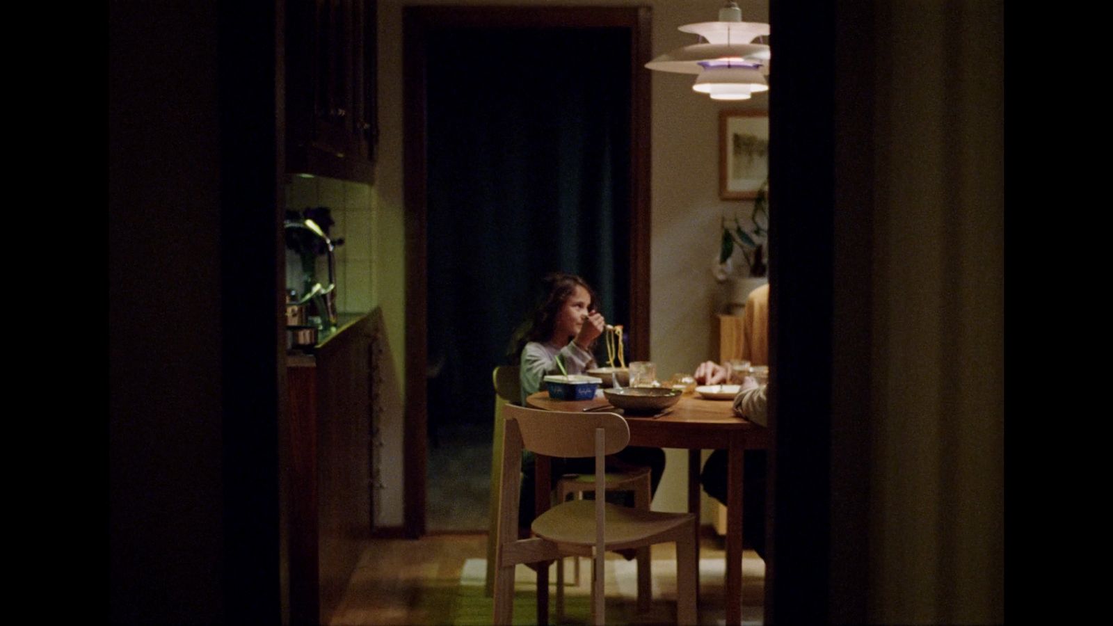 a woman sitting at a table in a dark room