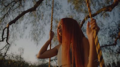 a woman with long red hair on a swing