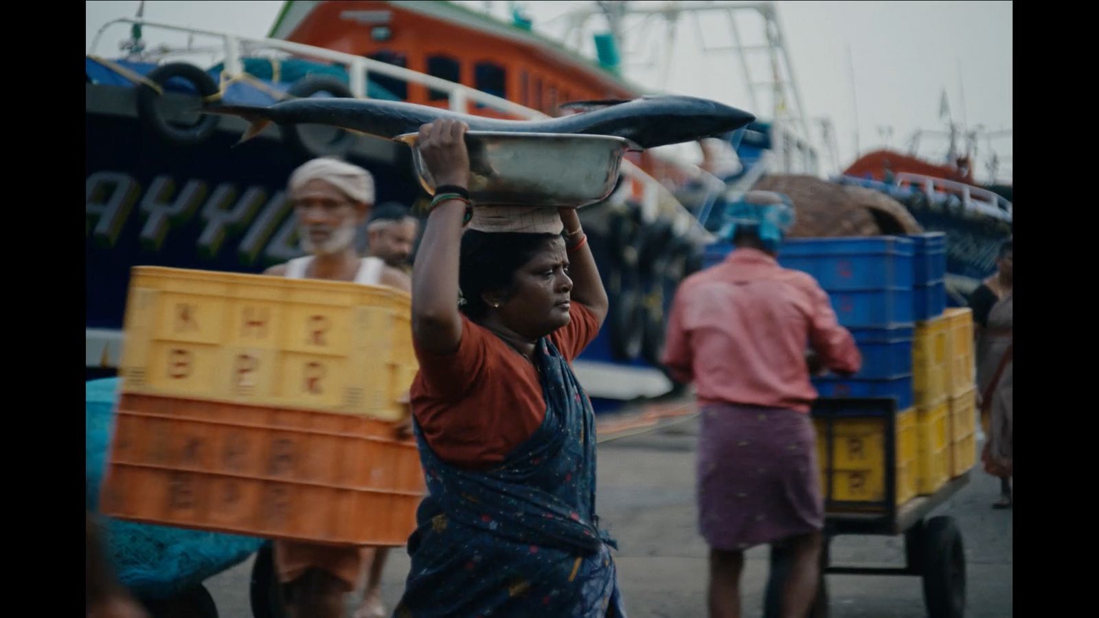 a woman carrying a tray on her head