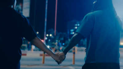 a couple of people holding hands on a street