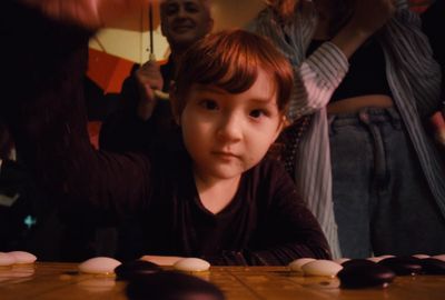 a little boy sitting at a table with cookies on it