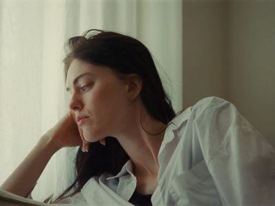 a woman sitting in front of a window reading a book